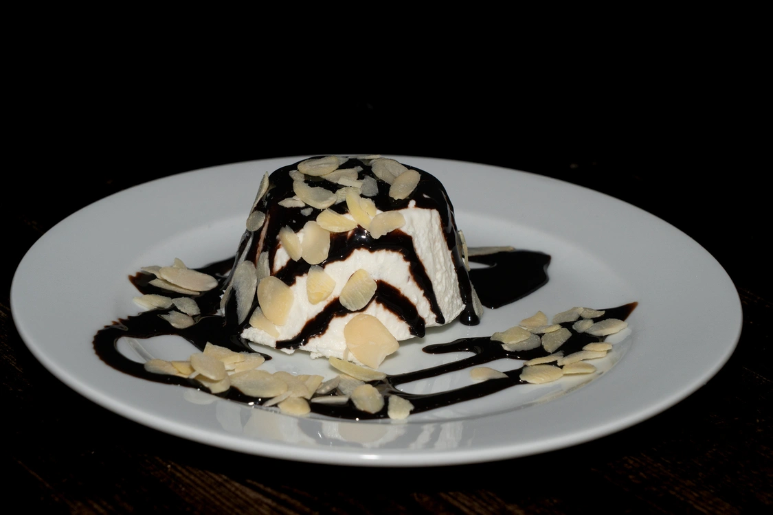 Dessert Parfait di Mandorle servito su un piatto bianco, decorato con colata di topping al cioccolato fondente e scaglie di mandorle tostate — Pizzeria Alla Botte, Misilmeri.