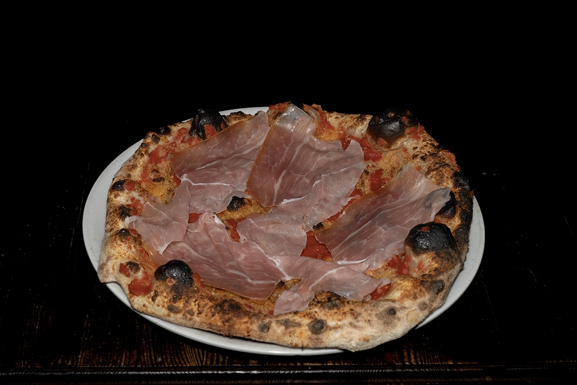 Pizza alla Billy Misilmeri con pomodoro, salame piccante, mollica, cipolla, grana, prosciutto crudo e acciughe — Pizzeria Alla Botte.