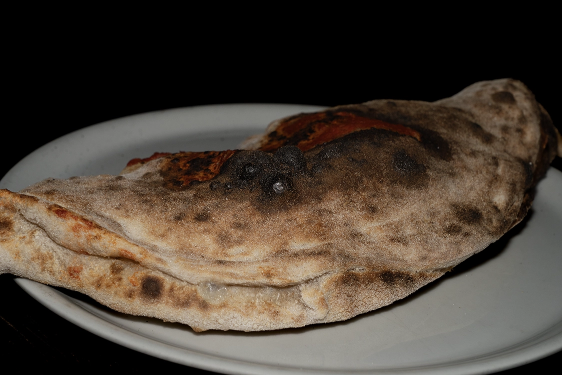 Calzone Farcito a Misilmeri con sette ingredienti: pomodoro, fior di latte, prosciutto, funghi, carciofi, salame piccante e wurstel — Pizzeria Alla Botte.