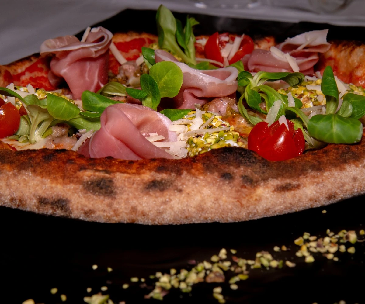 pizza levante con prosciutto cotto scelto granella di pistacchio datterino rosso e scaglie di grana