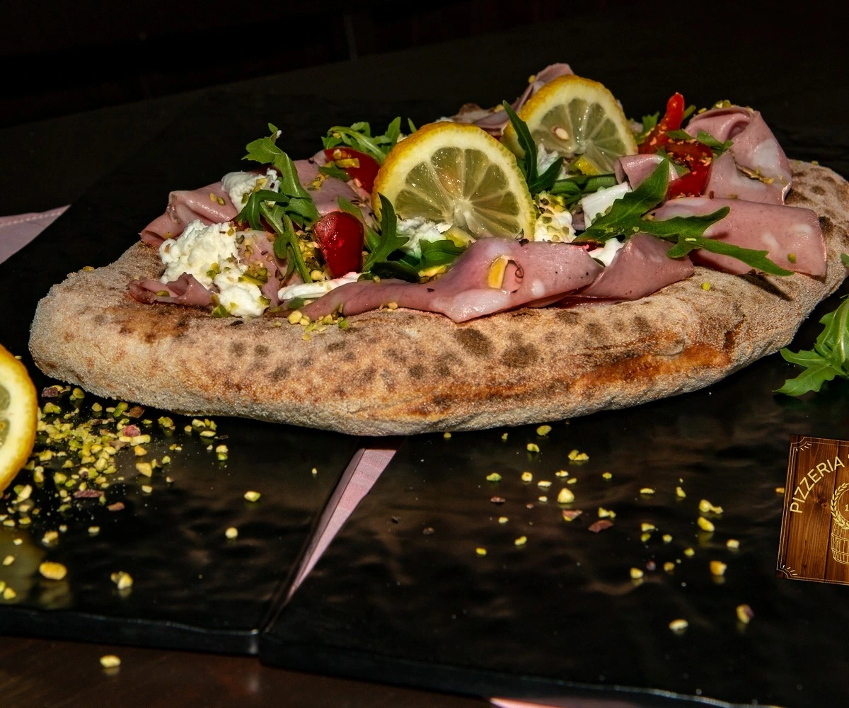 Pizza gourmet con mortadella, pistacchio e limone della Pizzeria Alla Botte a Misilmeri, disponibile con impasto integrale e senza glutine
