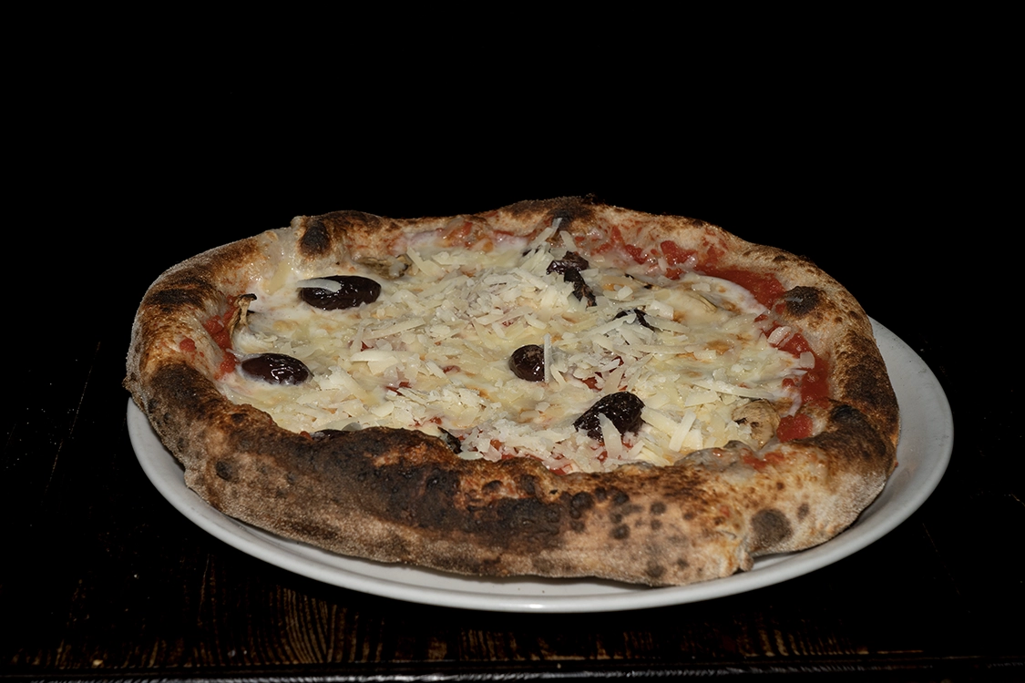 Pizza Parmigiana a Misilmeri preparata con melanzane grigliate, olive nere e scaglie di grana su impasto artigianale — Pizzeria Alla Botte.