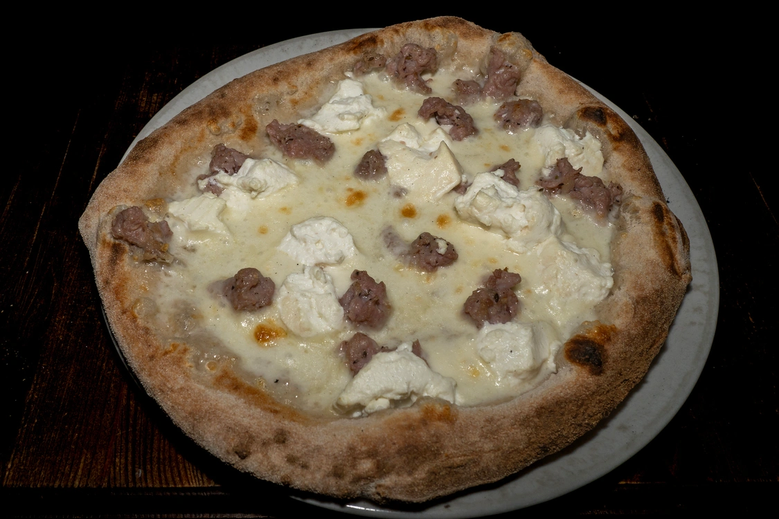 Pizza bianca "Pastore" con base fior di latte, generosi ciuffi di ricotta fresca e bocconcini di salsiccia saporita, cotta in forno a legna — Pizzeria Alla Botte, Misilmeri.