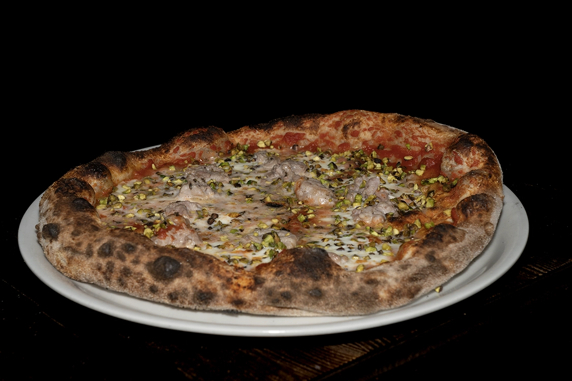 Pizza al Pistacchio Misilmeri condita con pomodoro, fior di latte, salsiccia, formaggio occhiatello e granella di pistacchio — Pizzeria Alla Botte.